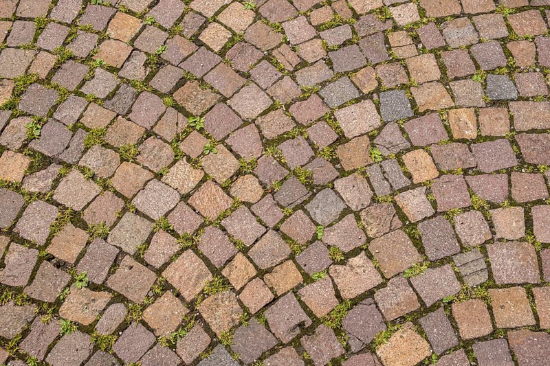 Paving stones in curved pattern with light moss growth in between, background, texture, North Rhine-Westphalia, Germany