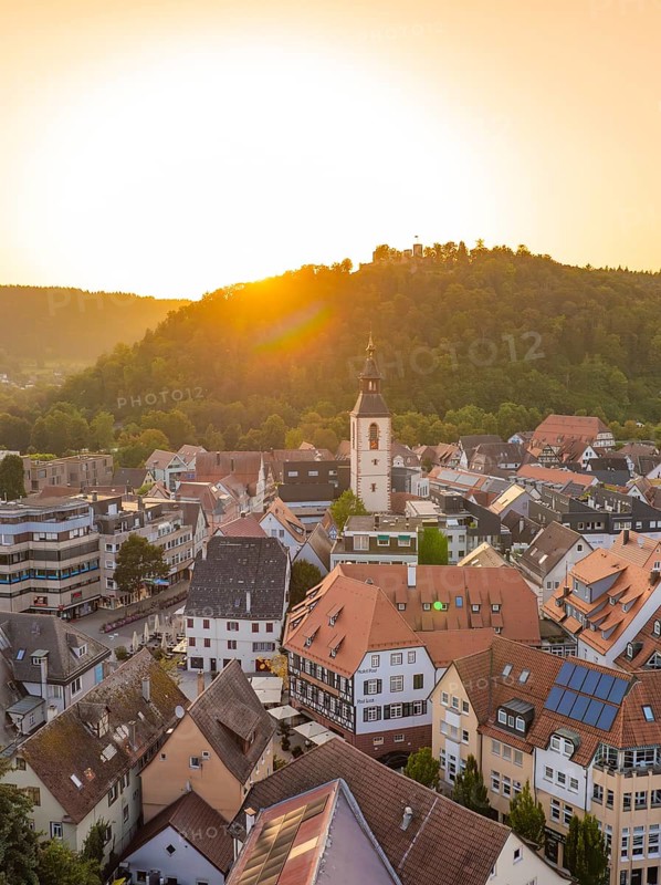 Sunny view of an old town with church and hills in the background at sunset, small town pearl Nagold, Black Forest, Germany