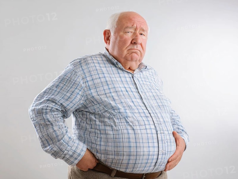 Elderly overweight man looks worried and holds his hands on his stomach, AI generated, AI generated