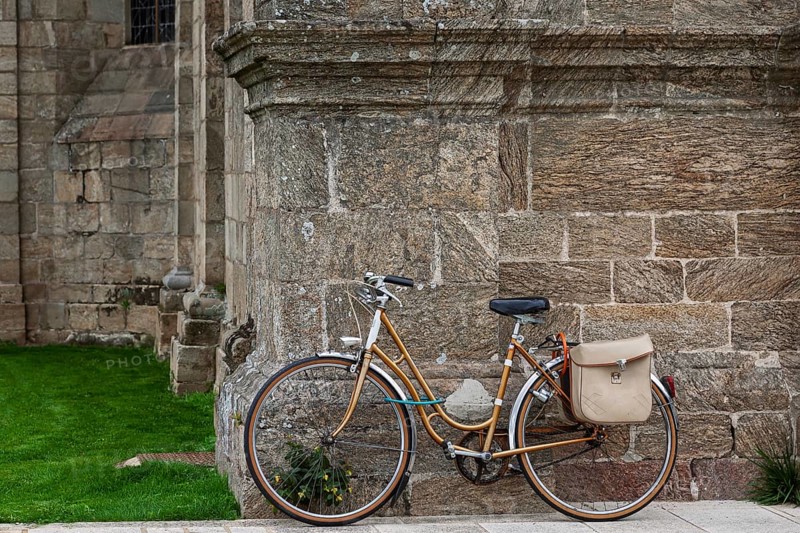 Women's bicycle leaning against a church façade, Guingamp, Brittany, France