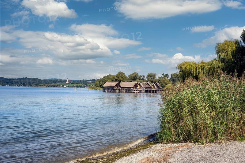 Blick über den Bodensee zu den Pfahlbauten, Pfahlbaumuseum Unteruhldingen, links am Horizont die barocke Wallfahrtskirche, Basilika Birnau, Bodenseekreis, Baden-Württemberg, Deutachland