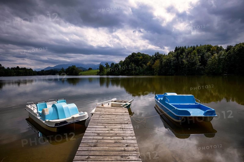 Rowing boat and pedal boats lying on a bathing jetty, jetty, wooden jetty, jetty, leads into a lake, bathing lake, Schwaltenweiher near Seeg, Allgäu Alps, East Allgäu, Allgäu, Swabia, Bavaria, Germany