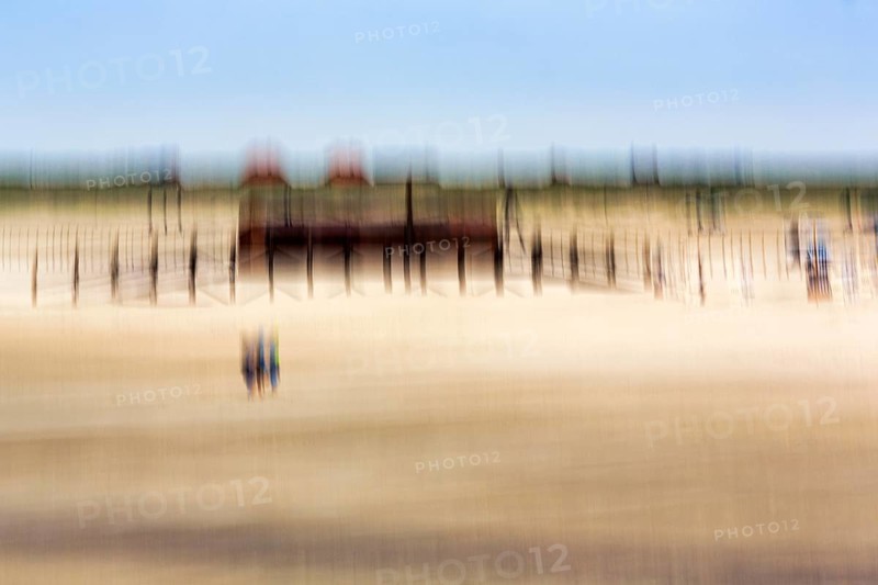 Three people on the North Sea beach, pile dwelling, stilt house, architecture, wipe effect, long exposure, Sankt Peter-Ording, Eiderstedt peninsula, Wadden Sea National Park, North Frisia, Schleswig-Holstein, Germany