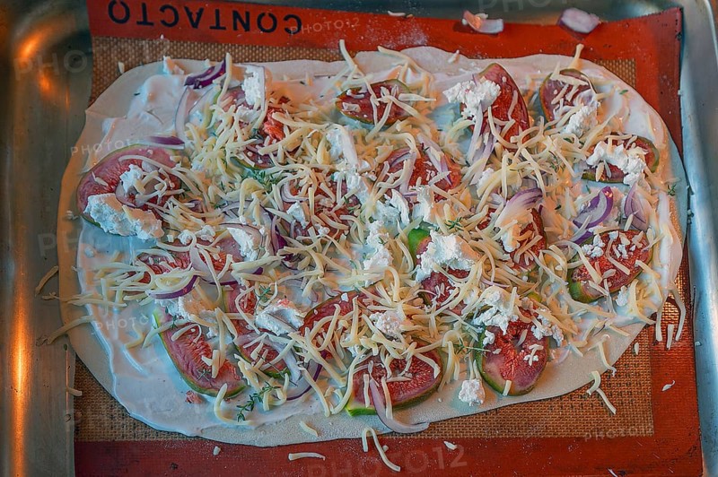 Tarte flambée with figs, onions and two types of cheese on a baking tray in the oven, Baden-Württemberg, Germany