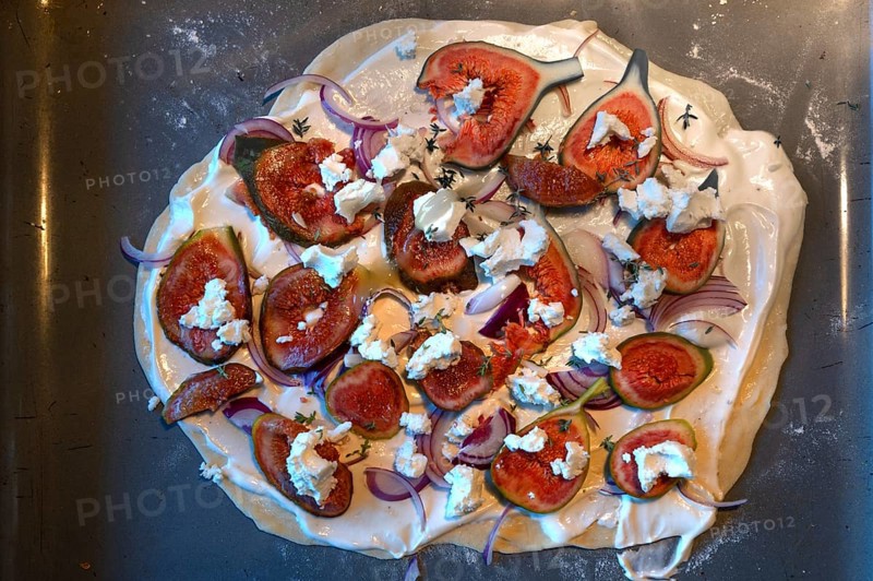 Tarte flambée with figs, goat's cheese and onions in the oven, Baden-Württemberg, Germany