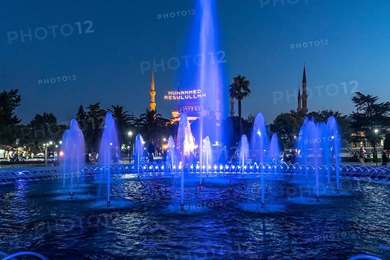 Majestic mosque providing a backdrop to illuminated fountains, creating a captivating scene in istanbul at twilight
