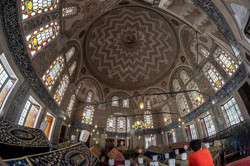 Wide angle view of the ornate ceiling and stained glass windows inside suleymaniye mosque, a historical landmark in istanbul, turkey