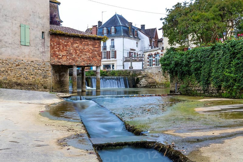The salt museum, a captivating landmark in salies de bearn, france, showcasing its rich salt history alongside a picturesque waterfall