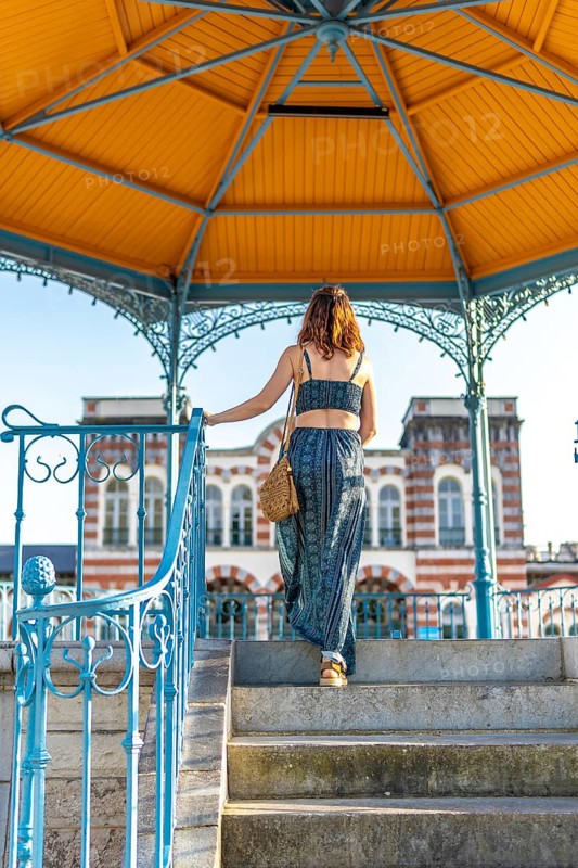 Tourist descending steps of colorful pavilion in salies de bearn, france, enjoying vacation and exploring local architecture