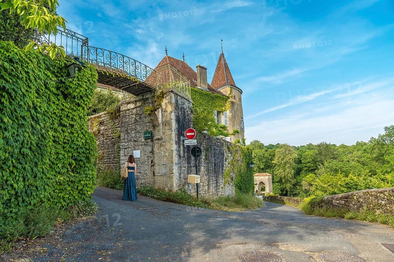 Tourist walking in the beautiful medieval village of sauveterre de bearn, in the pyrenees atlantiques department, in the nouvelle aquitaine region of southwestern france