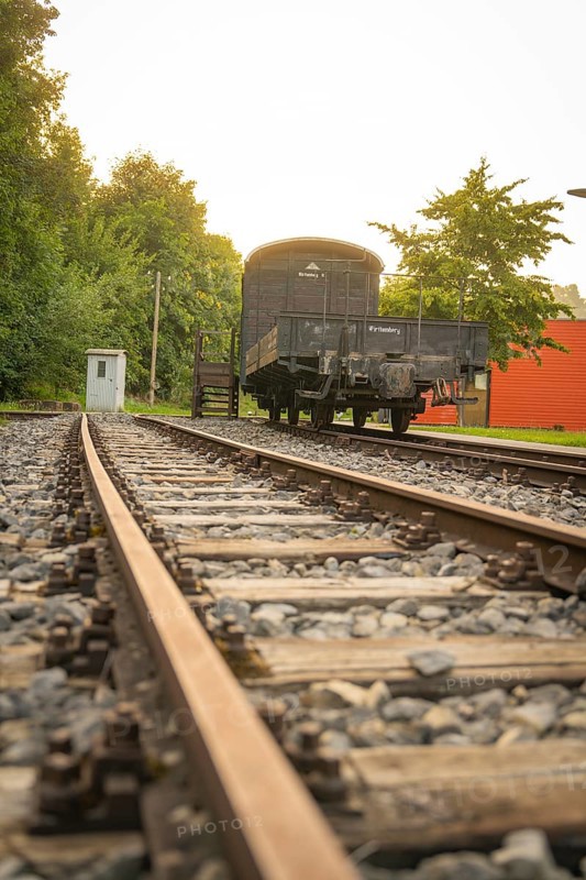 Railway tracks in the foreground leading to a historic train carriage, Nagold, district of Calw, Black Forest, Germany
