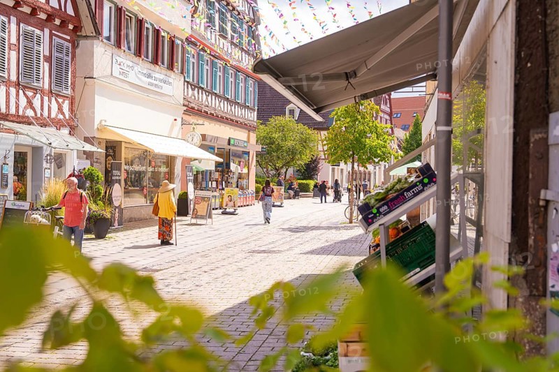 Sunny street in the old town centre with shops and passers-by, surrounded by historic architecture, small town pearl Calw, Black Forest, Germany