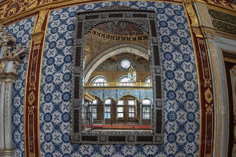 Luxurious mirror reflecting the ornate interior of a room in topkapi palace, showcasing ottoman architecture and design in istanbul, turkey