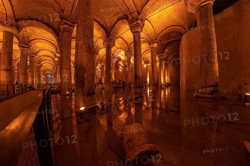 Warm lights illuminating columns and arches reflecting on the water surface of the basilica cistern in istanbul, turkey
