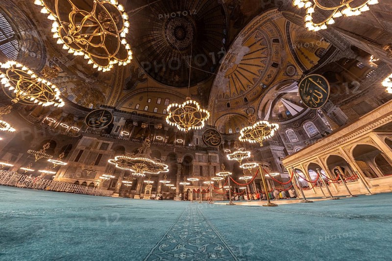 Wide angle view of the interior of hagia sophia in istanbul, turkey, showcasing its magnificent dome, intricate mosaics, and large chandeliers
