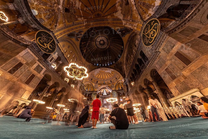 Tourists contemplating the impressive architecture and intricate details of the hagia sophia, a historical landmark in istanbul, turkey