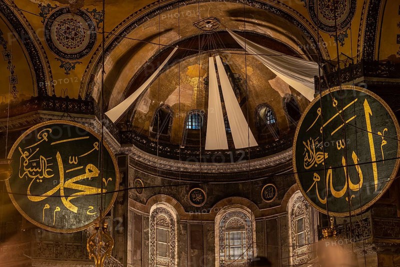 Interior view of hagia sophia showcasing islamic calligraphy, the central dome, and architectural details, illuminated by natural light