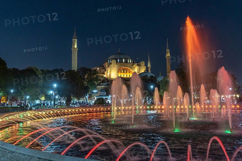 Colorful illuminated fountain jets dancing in front of the hagia sophia in istanbul, turkey, creating a magical night scene