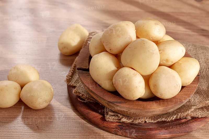 Boiled new potatoes, in a wooden bowl, on a rustic table, natural light, no people
