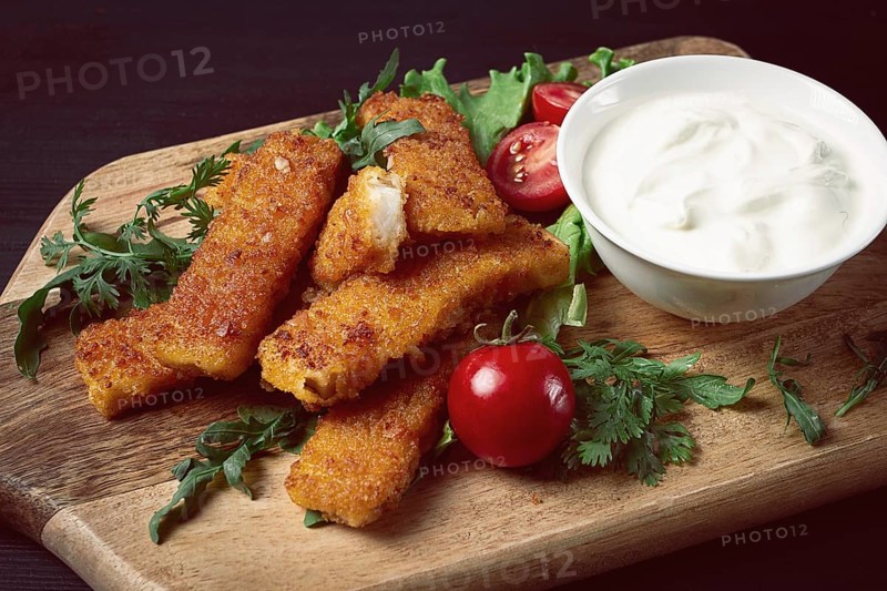 Fried fish nuggets, with white sauce, arugula and cherry, no people