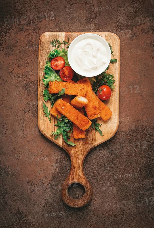 Fried fish nuggets, with white sauce, arugula and cherry, no people