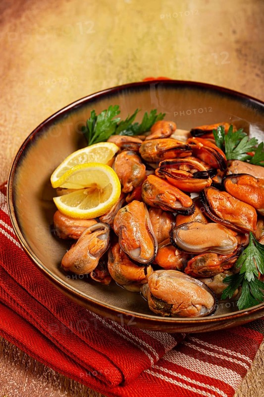 Mussels no shell, boiled, mussels, peeled, in a bowl, with lemon and parsley, Chilean mussels, top view, no people