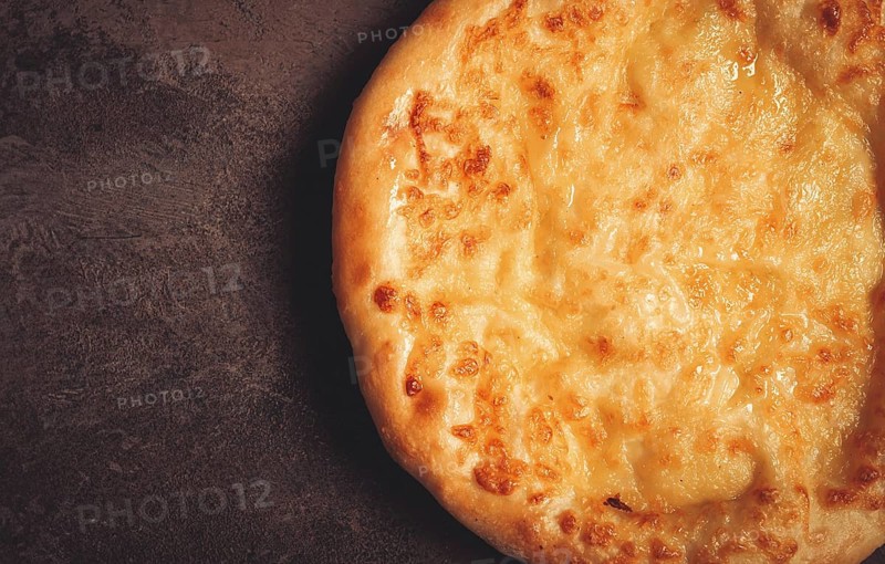 Khachapuri in Megrelian, a traditional Georgian dish, flatbread with cheese, top view, no people