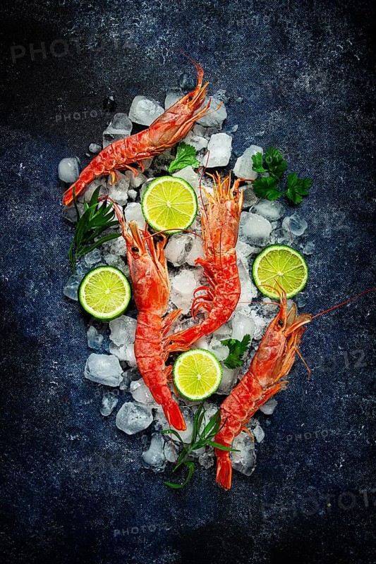 Langoustines, Australian, freshly frozen on ice, top view, lime and greens