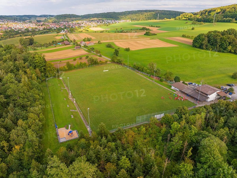 Sports field and buildings surrounded by trees and fields near a village, VFL Stammheim, Calw, Black Forest, Germany