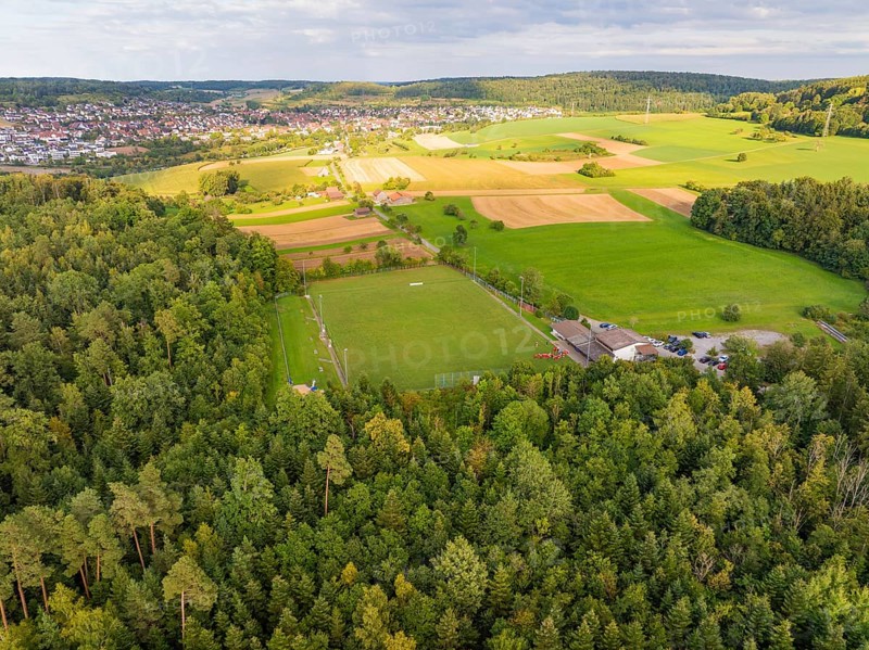 Sports ground next to woods and fields with a view of a village on the horizon, VFL Stammheim, Calw, Black Forest, Germany