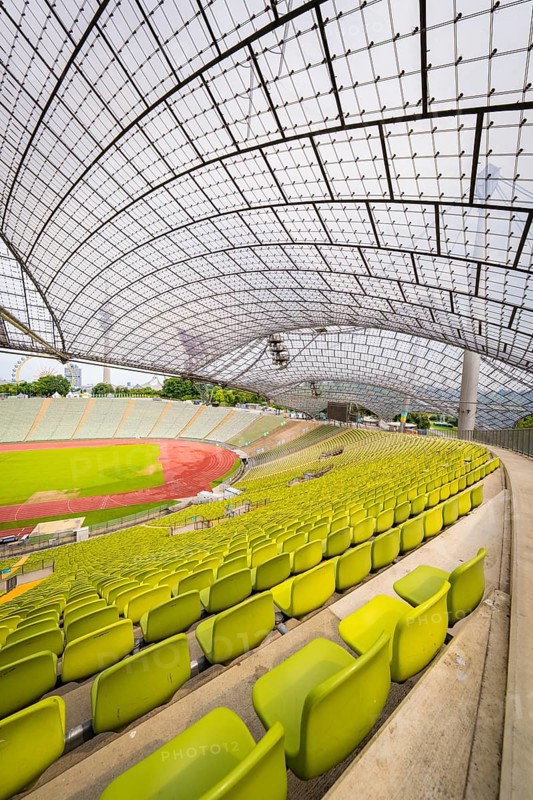 Stadium interior with yellow seats and an elegant roof design, Olympiapark, Munich, Germany