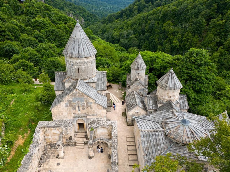 Historic stone monastery building, embedded in a wooded hilly landscape, aerial view, Haghartsin Monastery, Hagarzin, on the left Surp Astvatsatsin church, on the right Surp Stepanos and Surp Grigor churches and a gavit, Tavush province, Armenia