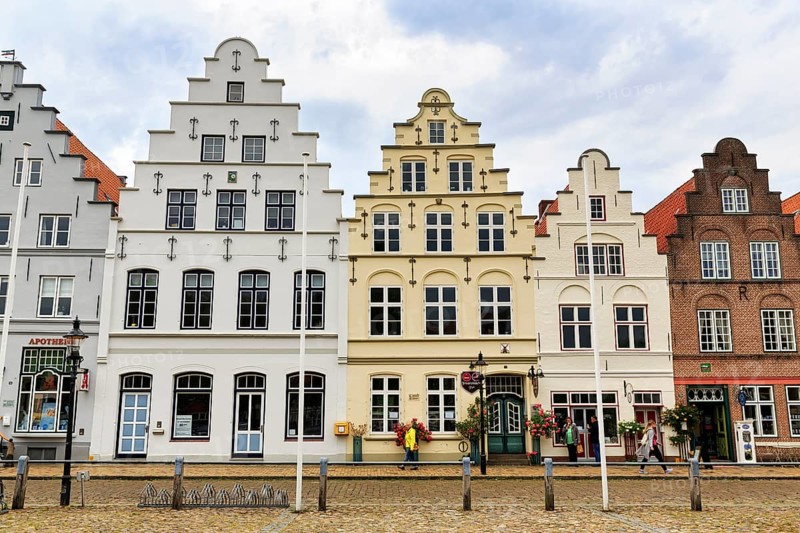 Historic stepped gabled houses on the market square, Dutch merchants' houses in the old town, passers-by, Friedrichstadt, Germany