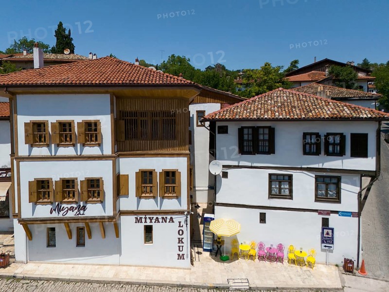 Two historic buildings with wooden windows and red roofs in sunny weather in a quiet street scene, aerial view, traditional Ottoman konaks, Safranbolu, UNESCO World Heritage Site, Karabük Province, Black Sea Region, Central Anatolia, Turkey