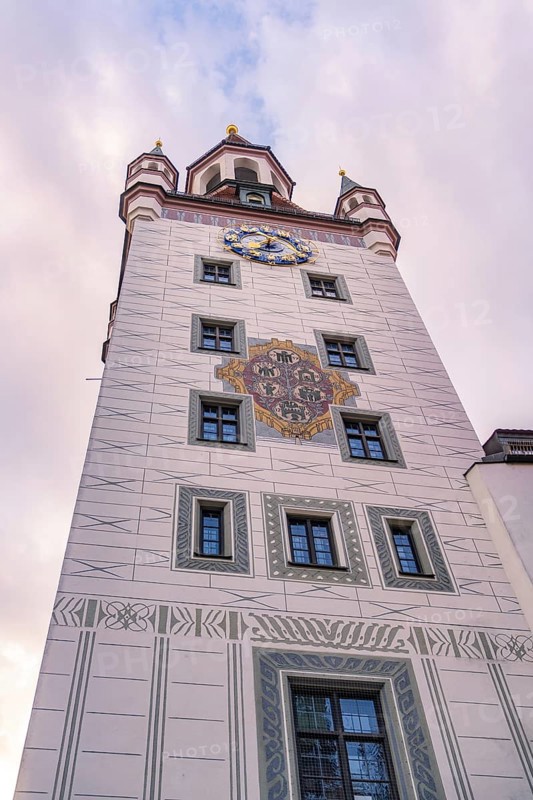 Decorated tower with clock in front of a pink cloudy sky, Munich, Germany