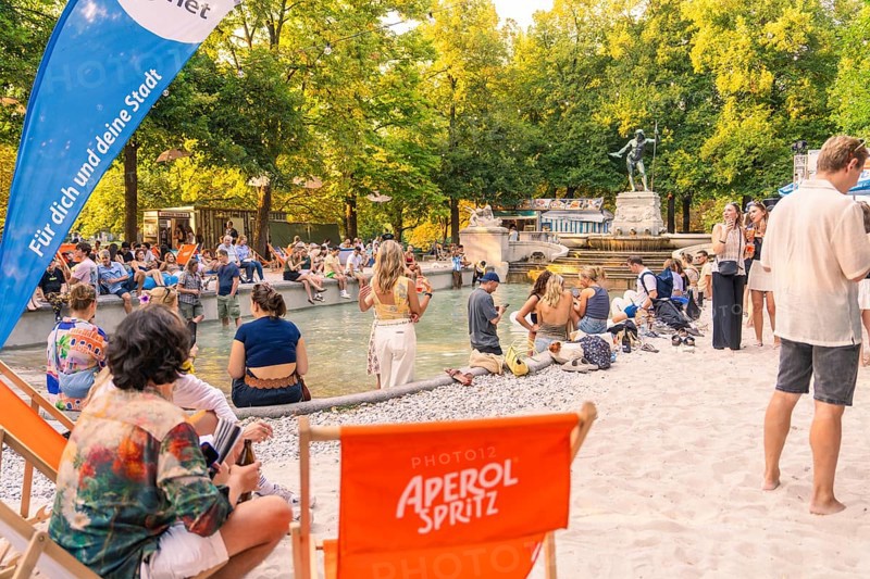 Summer atmosphere with numerous people at the fountain, Munich, Germany