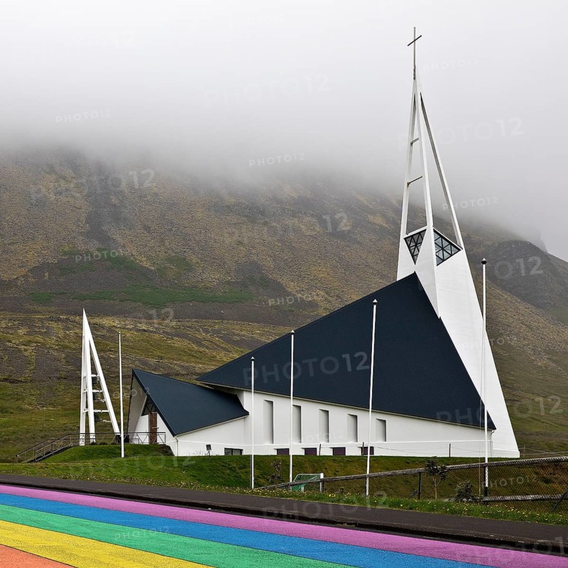 Street painted in the colours of the rainbow and the fish-shaped church designed by Hákon Hertervig, Ólafsvík, Snæfellsnes, Iceland