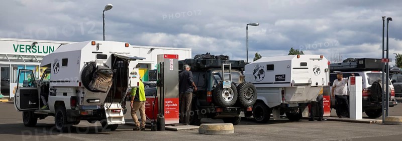 Several off-road vehicle drivers refuelling at self-service petrol stations, Reykjalith, Myvatn, Iceland