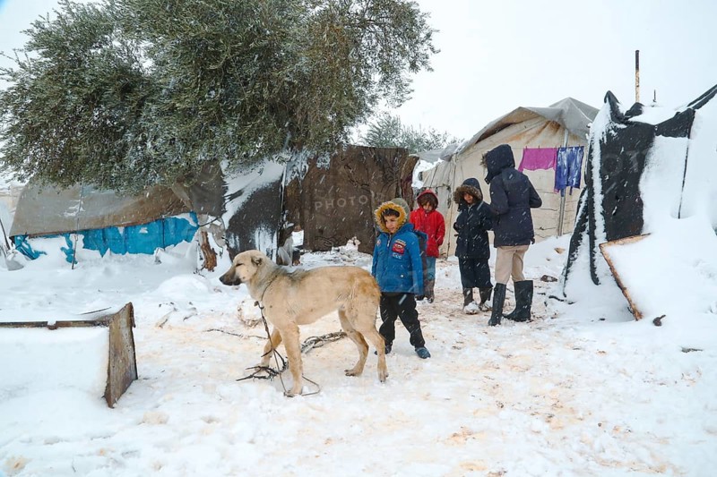 Displaced Syrian children playing in the snow near their tents inside a refugee camp during winter. Aleppo, Syria January 23, 2022, Aleppo, Syria