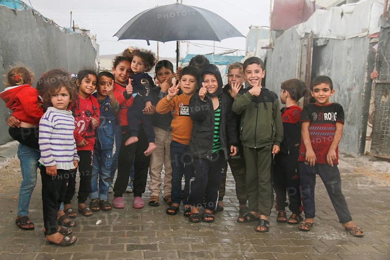 Syrian children inside the refugee camp taking a group photo under the rain on World Children's Day. Aleppo, Syria March 2, 2017, Aleppo, Syria