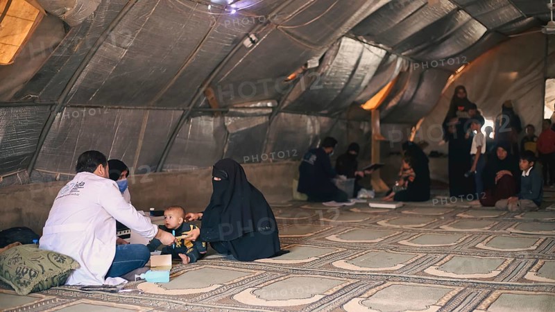 A doctor examining a woman inside a mobile medical point dedicated to treating Syrian refugees. Aleppo, Syria May 28, 2022, Aleppo, Syria