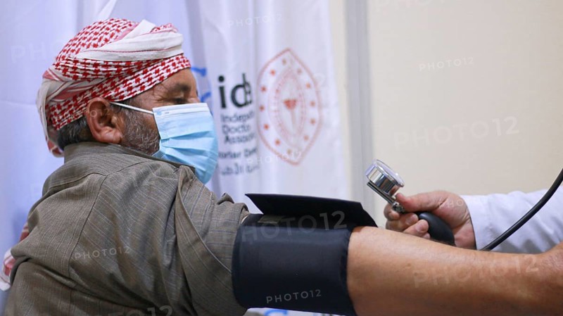 A Syrian doctor wearing a protective mask consults with a displaced patient inside a medical clinic. Aleppo, Syria May 28, 2022, Aleppo, Syria