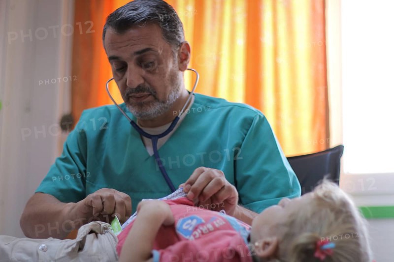 A doctor examining a displaced Syrian child inside a mobile clinic at a refugee camp. Aleppo, Syria October 29, 2022, Aleppo, Syria