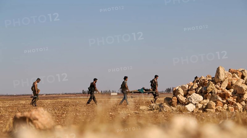Military fighters carrying a wounded man injured during a battle against ISIS in northern Syria. Aleppo, Syria October 16, 2016, Aleppo, Syria