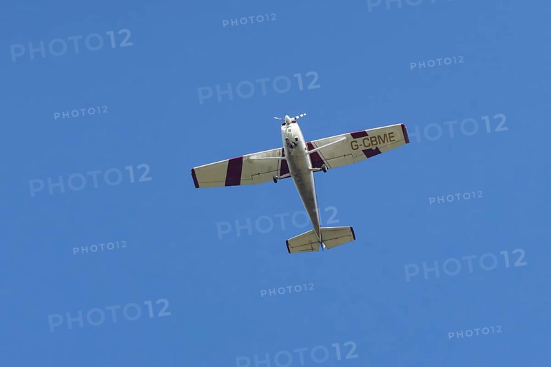 Reims Cessna F172M Skyhawk light aircraft flying in a blue sky, England, United Kingdom