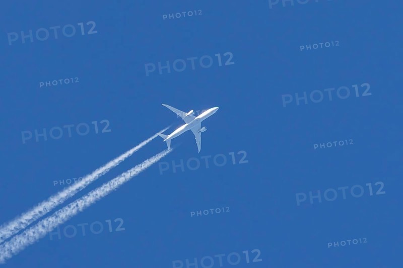 Boeing 787 Dreamliner jet passenger aircraft of KLM Royal Dutch airlines with a vapour trail or contrail flying in a blue sky, England, United Kingdom