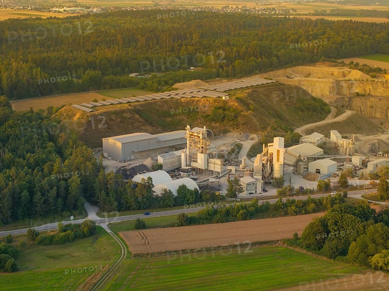 Aerial view of a factory surrounded by forests and fields in daylight, Wolfsberg Nagold industrial area, Calw district, Black Forest, Germany