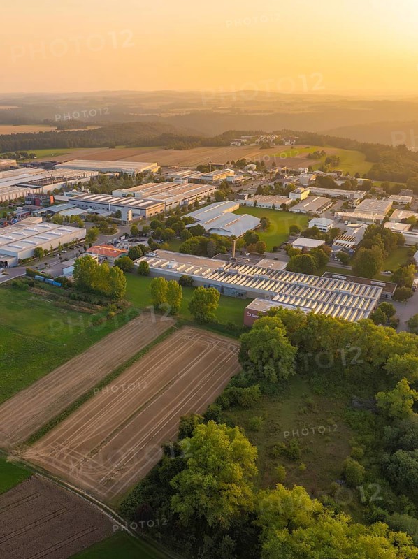 Aerial view of a rural industrial plant with fields and trees at sunset, industrial area Wolfsberg Nagold, district Calw, Black Forest, Germany