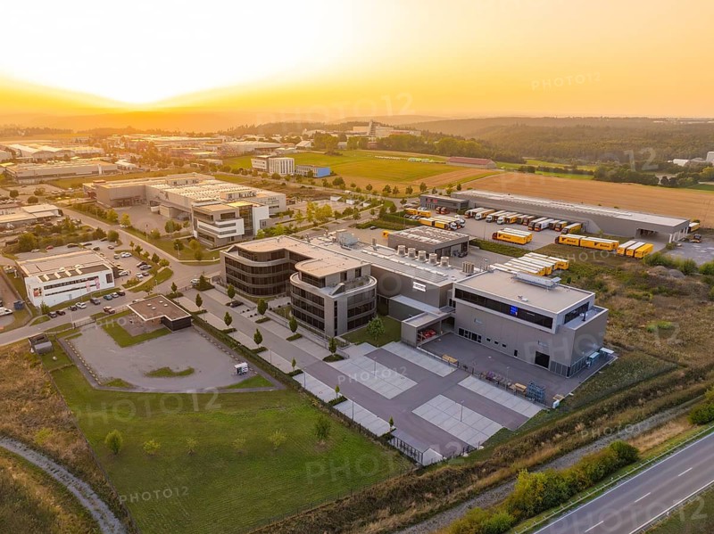 Modern office complex with extensive car parks and fields at sunset, Wolfsberg Nagold industrial area, Calw district, Black Forest, Germany