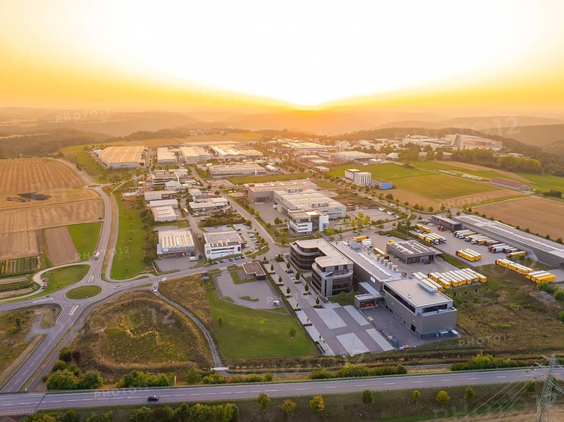 Industrial park at sunset, with symmetrical streets and a mixture of fields and buildings, industrial area Wolfsberg Nagold, district Calw, Black Forest, Germany